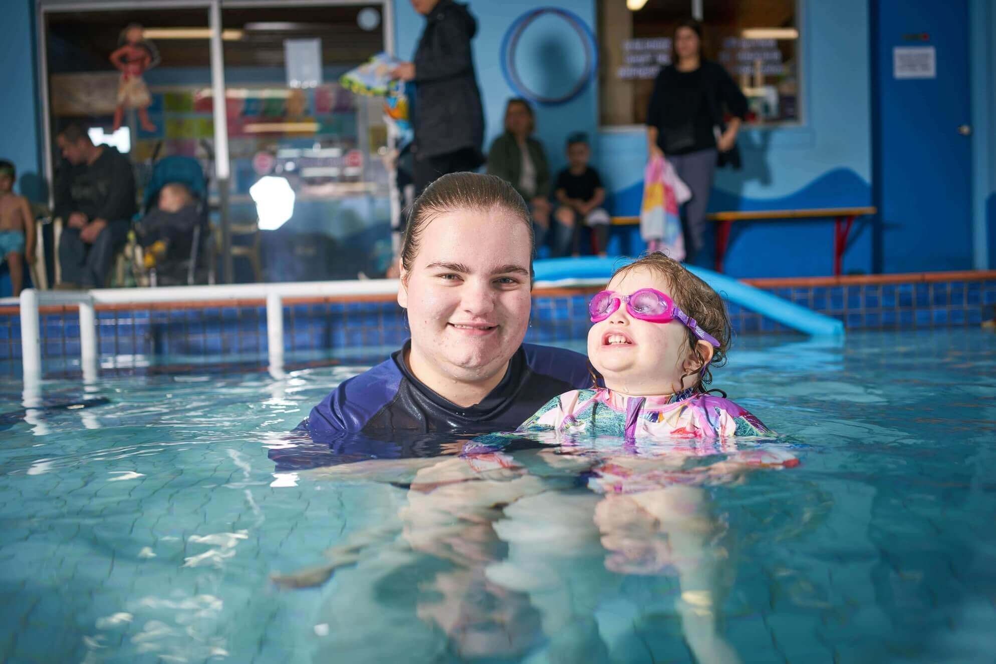 Maddy in a pool teaching a child