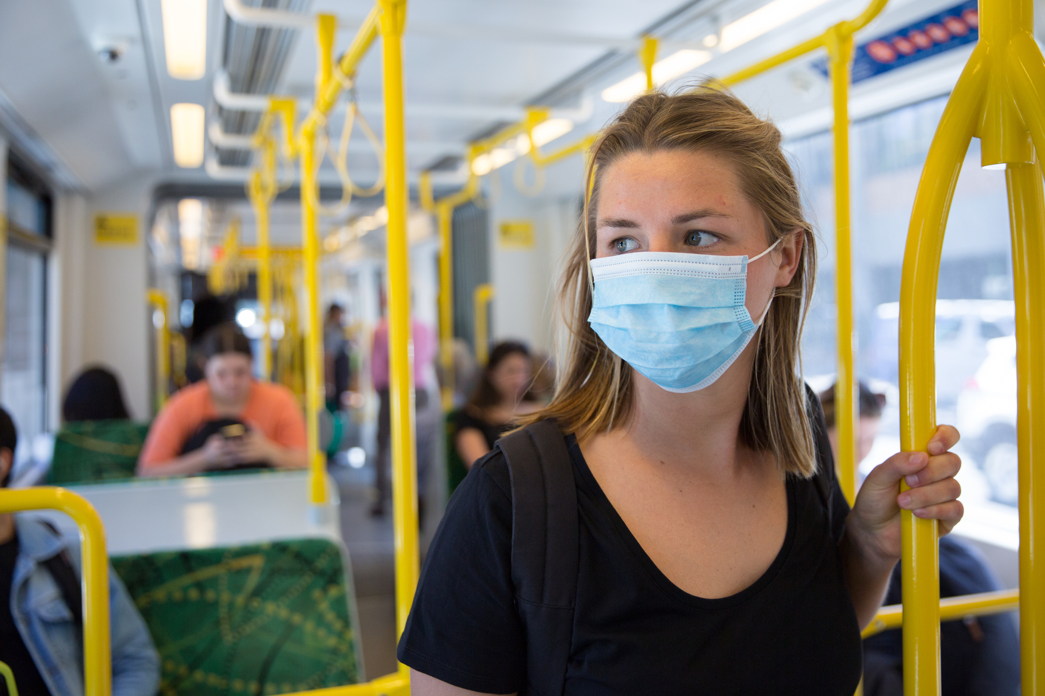 Woman in COVID-19 face mask on public transport