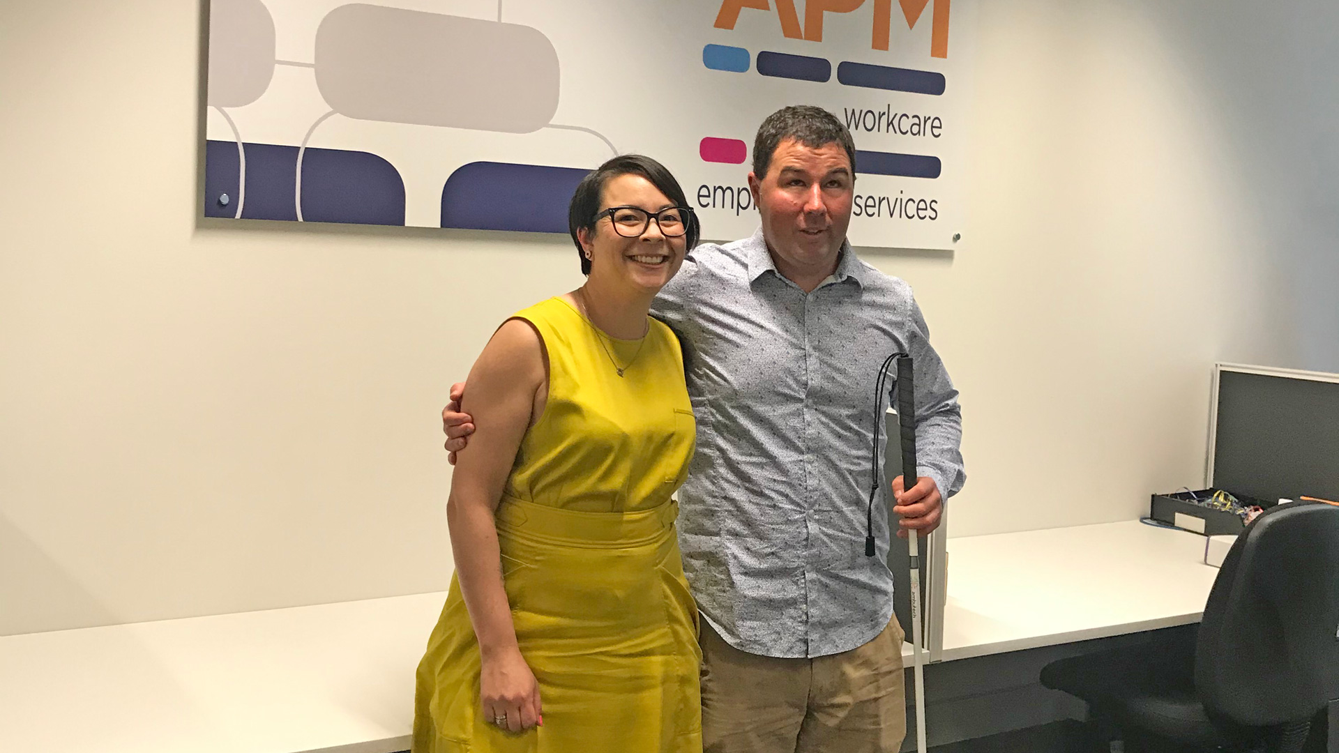 APM WorkCare's Amanda Johnston stands with Nathan in an APM office